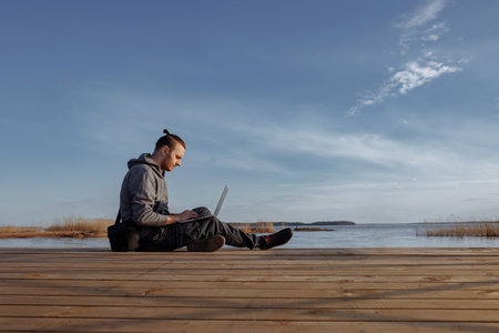 Young man working online on laptop outside