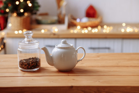 Ceramic white teapot and transparent glass jar on the tableの写真素材
