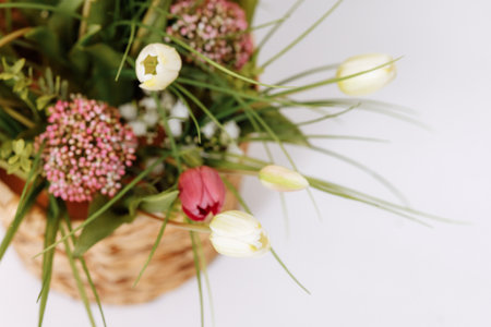 Basket with fresh spring flowers on a white background.の写真素材