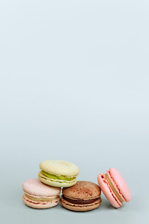 Sweet macaroons in pastel colors isolated on blue background.の写真素材
