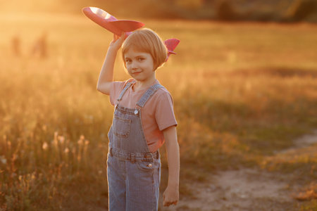 Child launches a toy plane in the fieldの写真素材