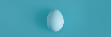 White egg on a light blue background in the center.の写真素材