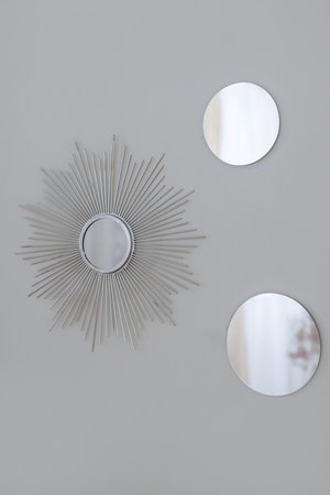 Silver round wall mirrors framed by Sun-Ray.の写真素材