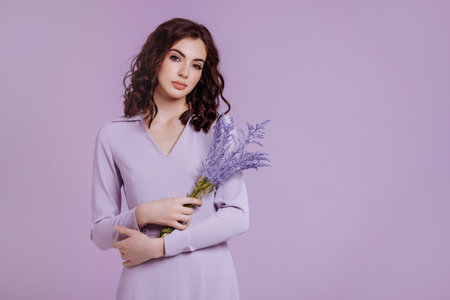 Attractive woman with bouquet on lilac backgroundの写真素材