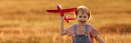 Child launches a toy plane in the fieldの写真素材