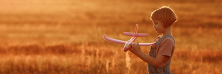 Child launches a toy plane in the field
