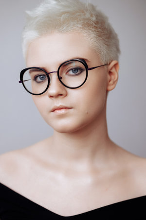 Portrait of a beautiful blonde woman with a short haircut on a white backgroundの写真素材