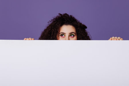Woman peeking out from behind a bannerの写真素材