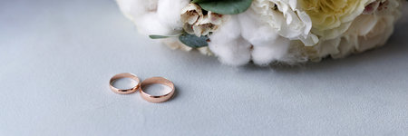 A wedding bouquet and two golden wedding rings