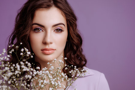 A brunette girl holds a bouquet of gypsophila flowers in her hands.の写真素材