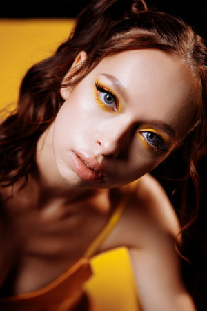 Young Adult Woman with Long Red Hair and Confident Look in Studio Portraitの写真素材