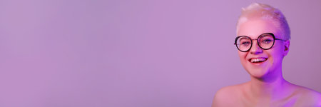 Portrait of a beautiful young woman with short hair on a pale pink neon backgroundの写真素材