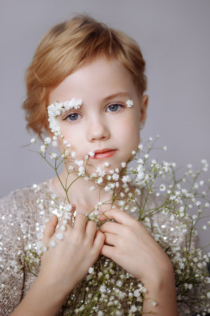 Portrait of a beautiful blondie child with perfect skin and creative floral makeup.の写真素材