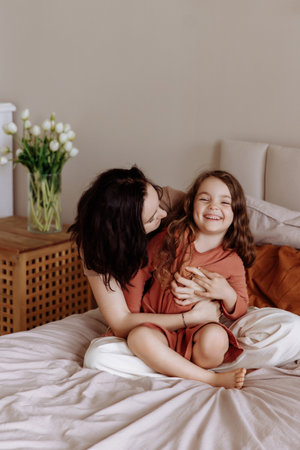 Mother and her daughter child girl playing and hugging. Happy loving family.の写真素材
