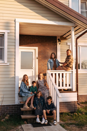 Happy big family on the porch of the ranch-style houseの写真素材