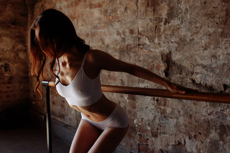 Beautiful sportswoman on the background of a brick wall