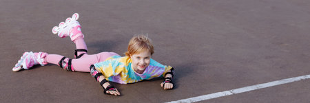A little girl fell on roller skates. Learns to ride.の写真素材