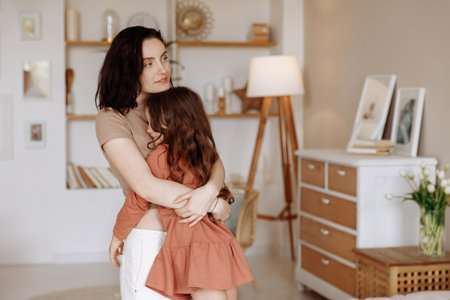 Cute little girl hugging happy young mother