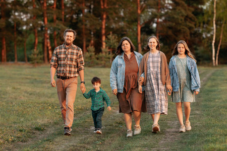 A large friendly family goes to the field in the summer.の写真素材