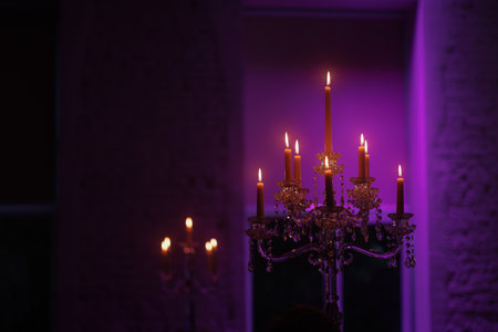 Candelabra with candles in purple backlit backgroundの写真素材