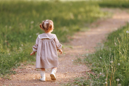 Small child girl walking in the park.の写真素材