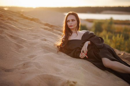Woman relaxing on beach at sunsetの写真素材