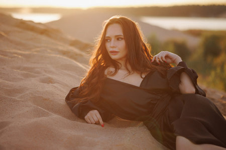 Woman relaxing on beach at sunsetの写真素材