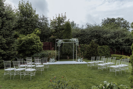 Beautiful wedding arch decorated with flowers and chairs for guestsの写真素材
