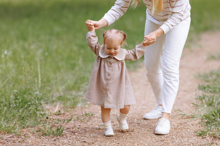 Woman in white clothes have fun with cute child baby girl 1-2 year oldの写真素材