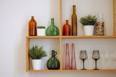 Wooden shelves with bottles, glasses, and plants.
