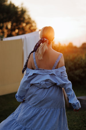 Portrait of a beautiful blonde in the village rear viewの写真素材