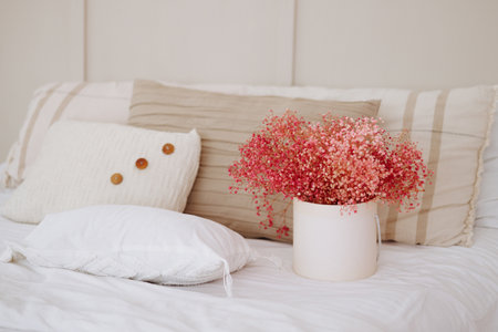 Cozy, serene bedroom with pink flowers.の写真素材