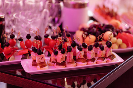 A table with a variety of appetizers and desserts, including fruit skewersの写真素材