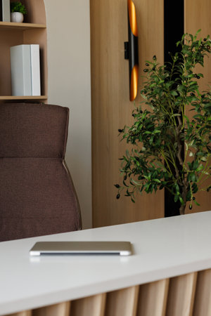 A brown chair is in front of a desk with phoneの写真素材