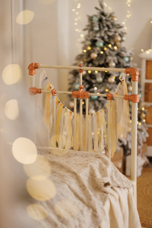 Kids bedroom with a retro bed with a and lace pillows and a decorated Christmas tree.の写真素材