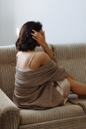 Relaxed beautiful young woman resting with eyes on sofa at home enjoying rest.の写真素材