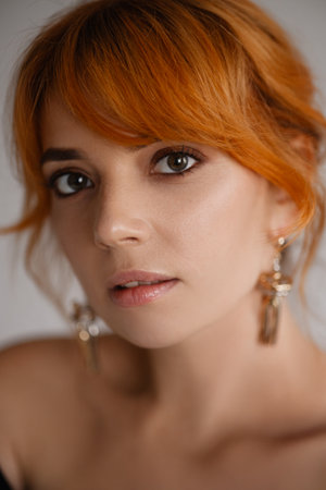 Close-up portrait of a young woman with bright red hair