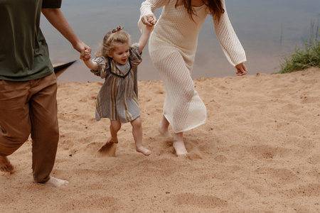 Caucasian family walking along a serene lake shore in nature.の写真素材
