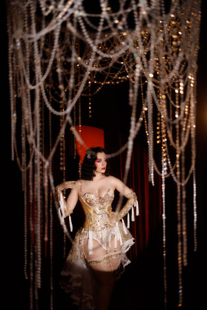 Circus-inspired retro burlesque dancer posing in golden corset with theatrical decor
