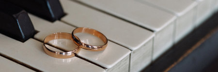 Banner two wedding rings on piano keys.の写真素材