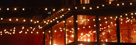 Banner string lights over building with brick wall and window background