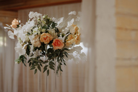 White floral wedding arrangement on metal stand with blurred lights in backgroundの写真素材