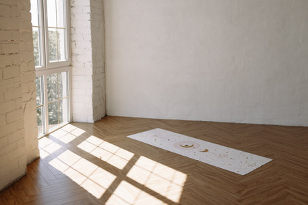 Yoga mat on wooden floor by white wall and large window with copy spaceの写真素材