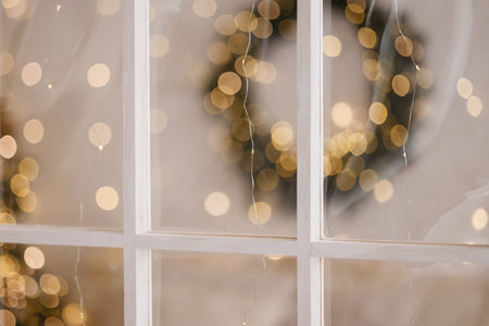 White wooden window frame with blurred warm lights in festive indoor settingの写真素材