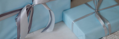 Banner blue gift boxes with silver ribbons on light wooden floorの写真素材