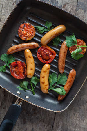 Sausages on board on wooden backgroundの写真素材