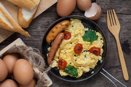 Scrambled eggs with fried sausages, served in a panの写真素材