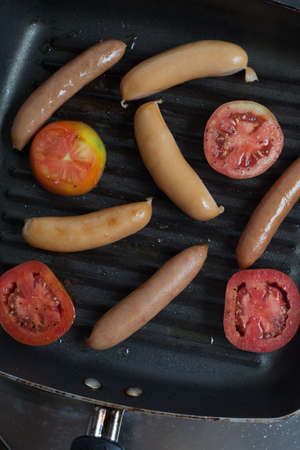 Sausages on board on wooden backgroundの写真素材