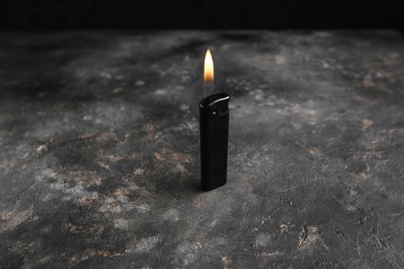 gas lighter with fire on a black background