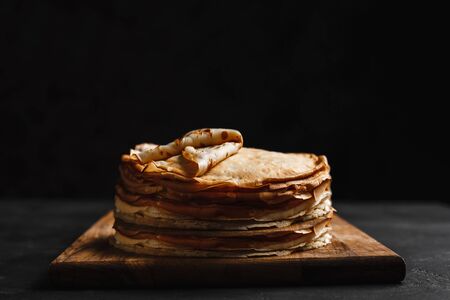 Maslenitsa Maslenitsa week is a holiday of food. A stack of Russian pancakes on a dark rustic wooden background. Front view with copy spaceの写真素材